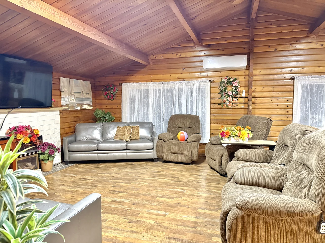 The living room at Birdsong Adult Family Home in Kent, with log walls, a vaulted wood ceiling and recliners